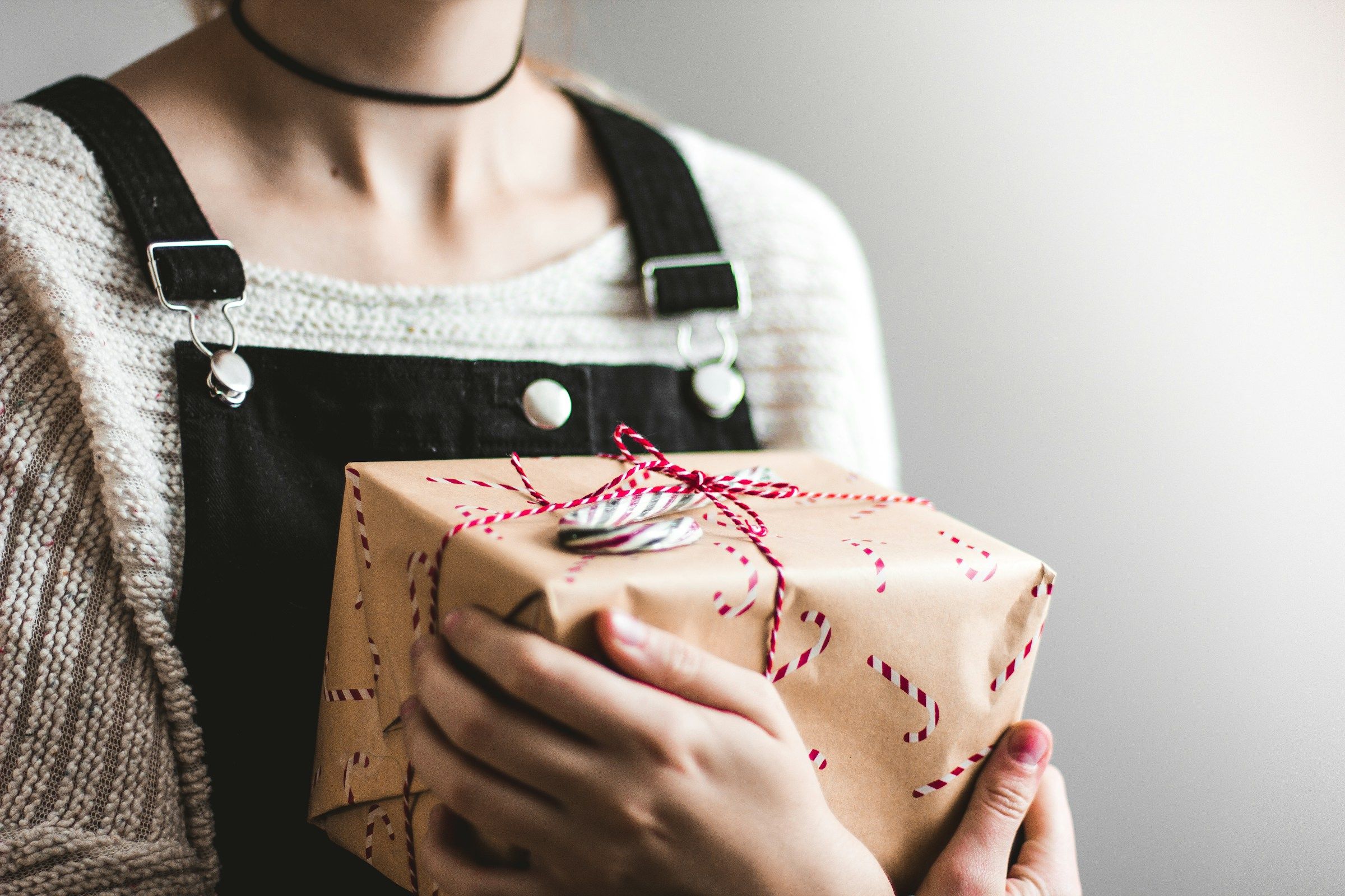 woman holding a gift package - Onboarding Gifts For New Hires