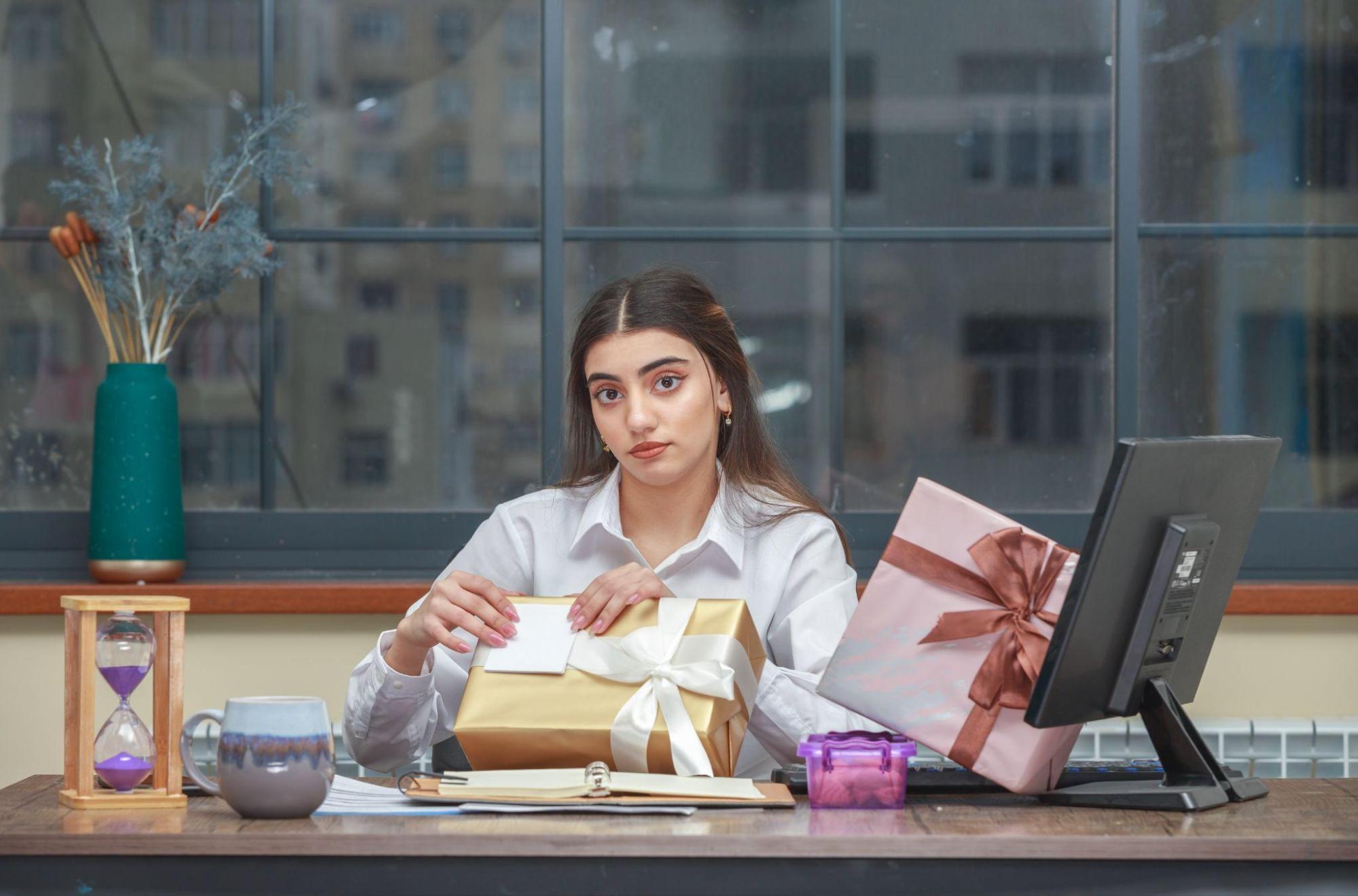 businesswoman opening gifts on her desk